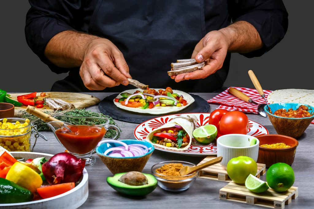 A street vendor preparing a Mexican dish