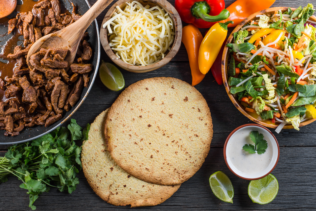 A table with tortillas, Mexican meat, and cheese from a food manufacturing company in El Paso.